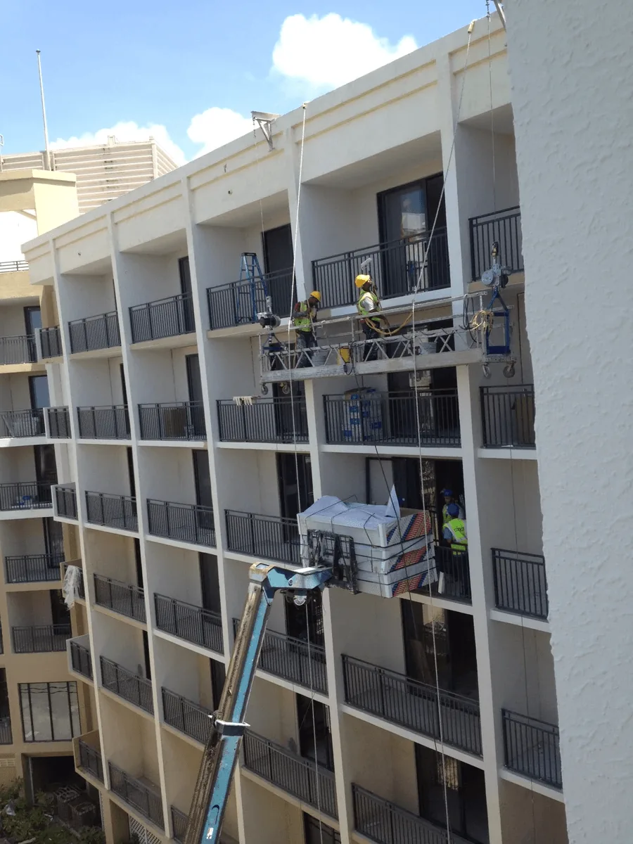 Trabajos exteriores en balcones de edificio de varios pisos con plataforma elevadora