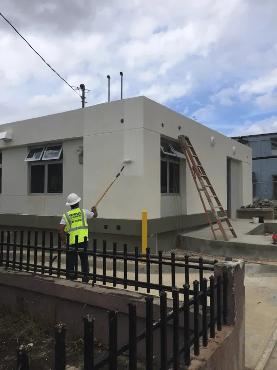 Obrero de Empresas César Díaz pintando la fachada de un edificio