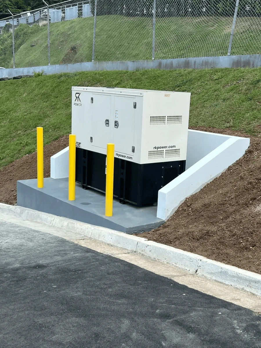 Generador eléctrico instalado sobre losa de concreto nueva con bolardos de protección