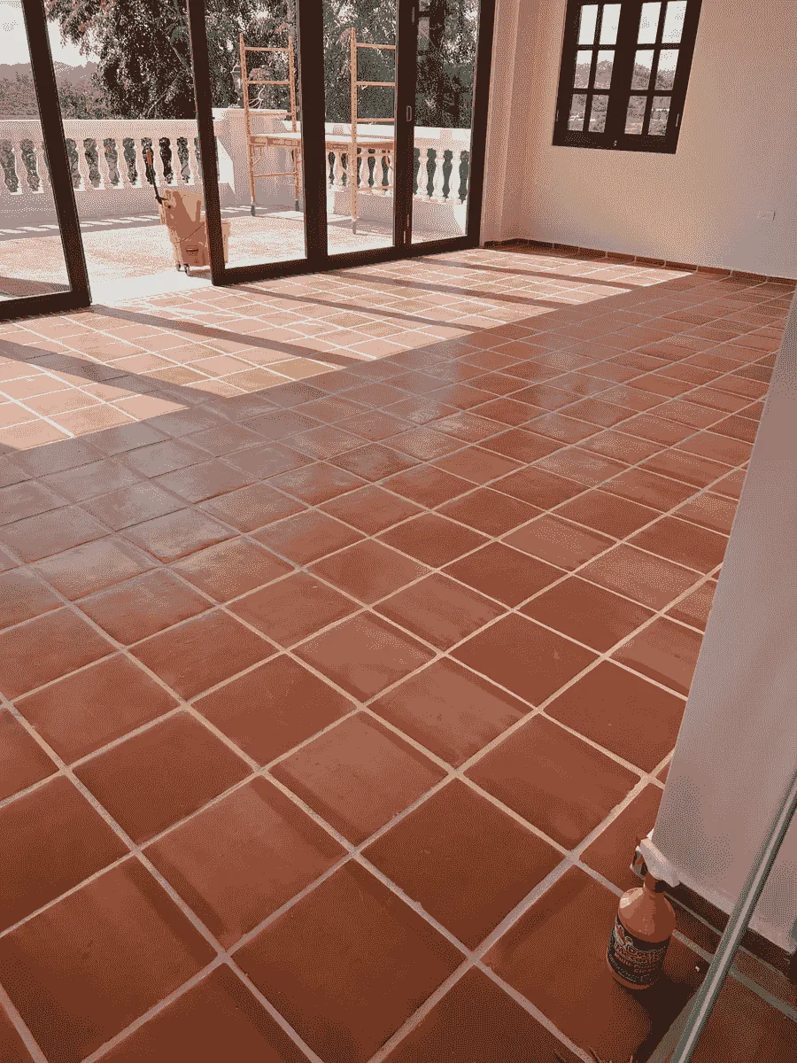 Piso de terracota instalado en un salón amplio con puertas de madera