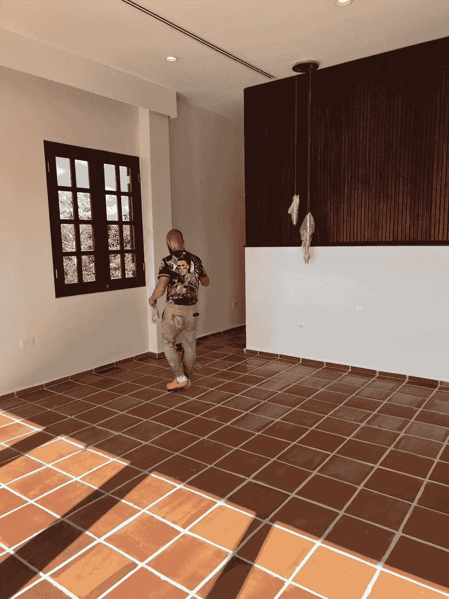Interior remodelado con piso de terracota y pared de madera